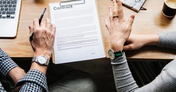 Trial lawyer with a victim signing a contract